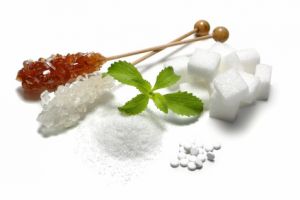 Auf der Suche nach einer gesunden Zuckeralternative buhlen Erythritol, Stevia & Xylitol um die Gunst des Käufers. © fovito - Fotolia.com Zuckeralternative: Brauner Kandis, Zuckerkristalle, Süßstoff Acesulfam, Sucolin und Birkenzucker auf einem Tisch.