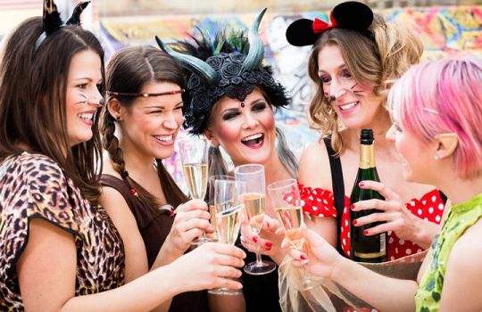 Verkleidete Mädelsgruppe trinkt Sekt und hat viel Spaß bei der Weiberfastnacht.
