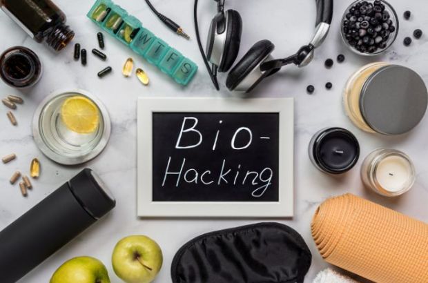 Fotografie einer Ansammlung diverser Gegenstände, die im Biohacking eine Rolle spielen, das Wort 'biohacking' auf einer Schiefertafel