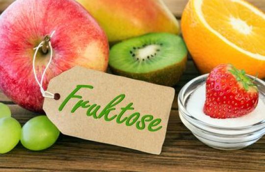 Obst auf eine Tisch, an einem Apfel hängt ein Schild auf dem 