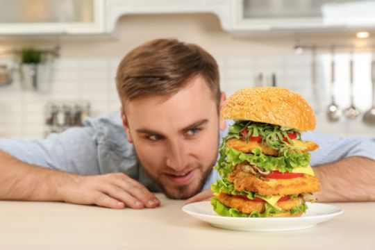 Junger Mann liebäugelt mit einem riesigen Burger. © New Africa - Fotolia.com