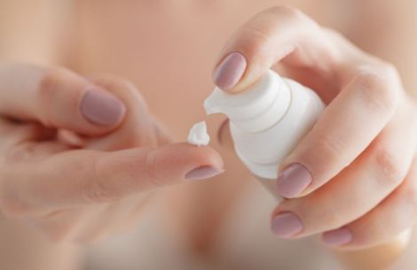 Frau drückt Creme aus Spender