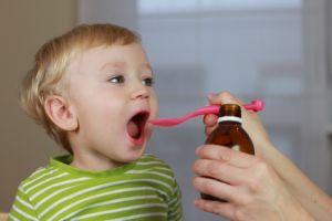 Auch Kinder können bei Erkrankungen mit Heilpflanzen behandelt werden. © Joanna Zielinska - Fotolia.com Ein Kinder erhält einen Löffel mit einer Siruplösung.